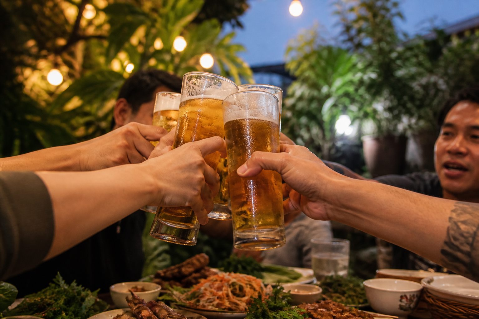 Nhóm bạn nâng ly bia bên bàn món Việt